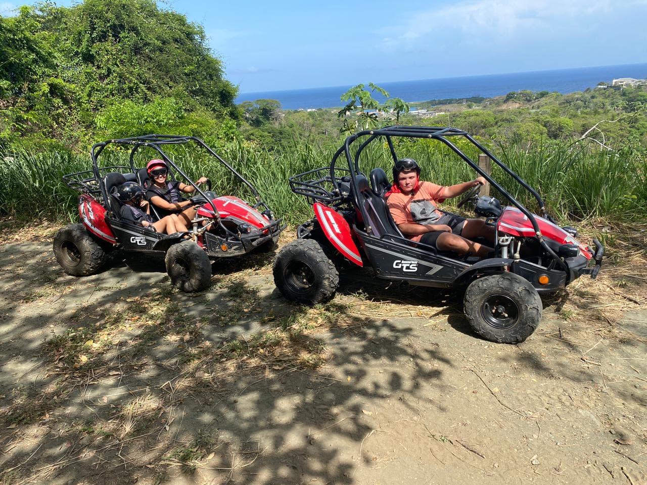 Two women covered in mud driving a dune buggy